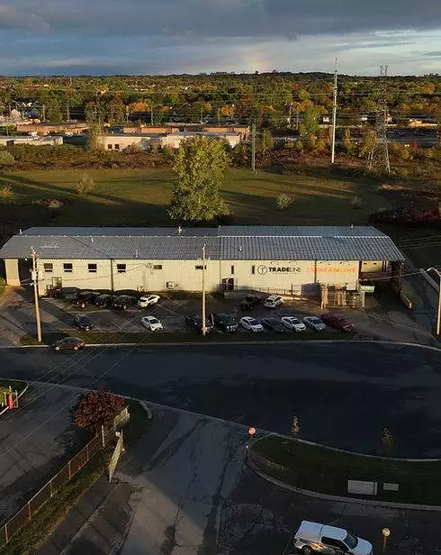 An aerial view of a building with cars parked in front of it showcasing custom metal fabrication.